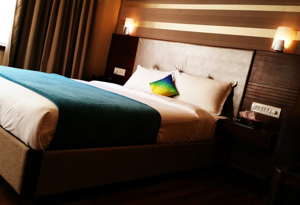 Can Anyone Book a Hearing Accessible Hotel Room? Here’s What You Need to Know hotel room with warm lights mounted above the headboard