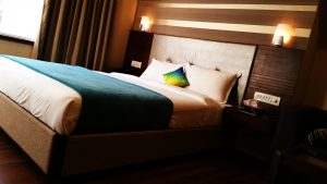 hotel room with warm lights mounted above the headboard
