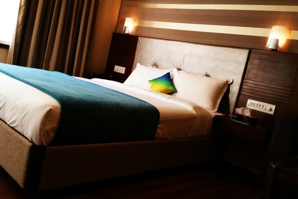 Can Anyone Book a Hearing Accessible Hotel Room? Here’s What You Need to Know hotel room with warm lights mounted above the headboard