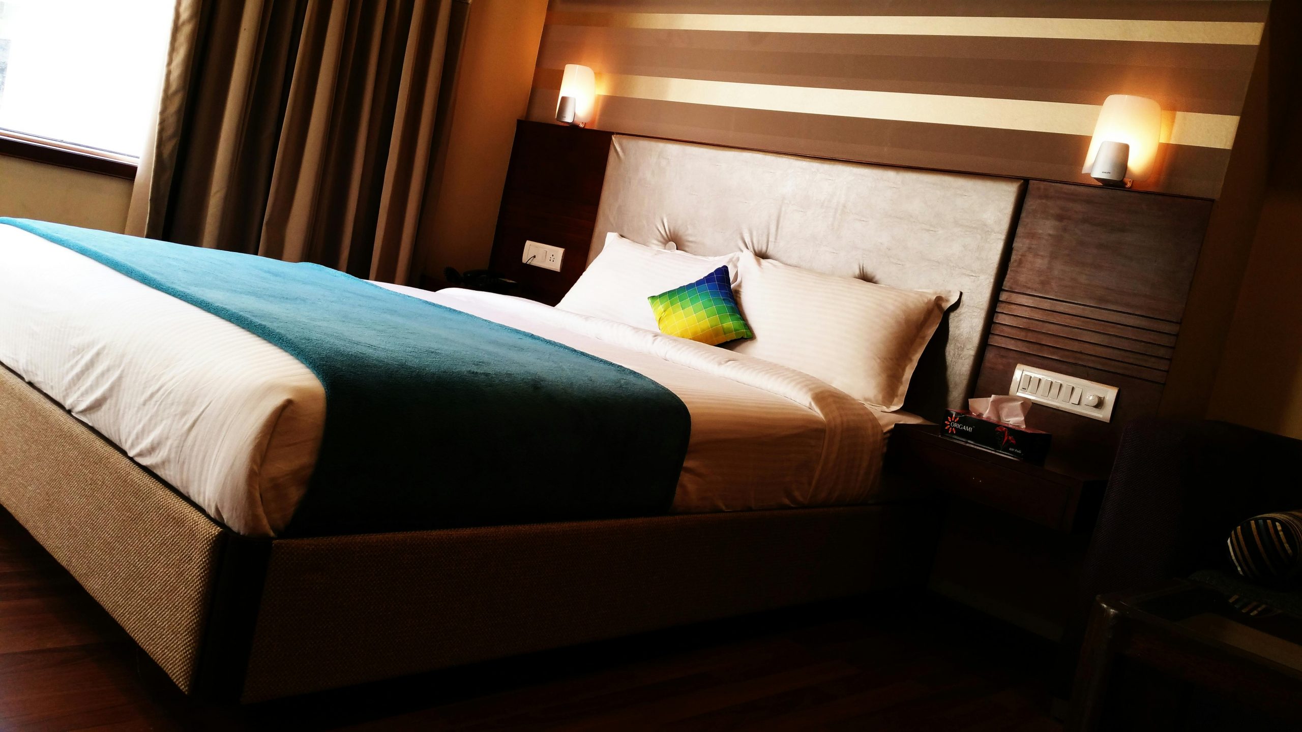 hotel room with warm lights mounted above the headboard