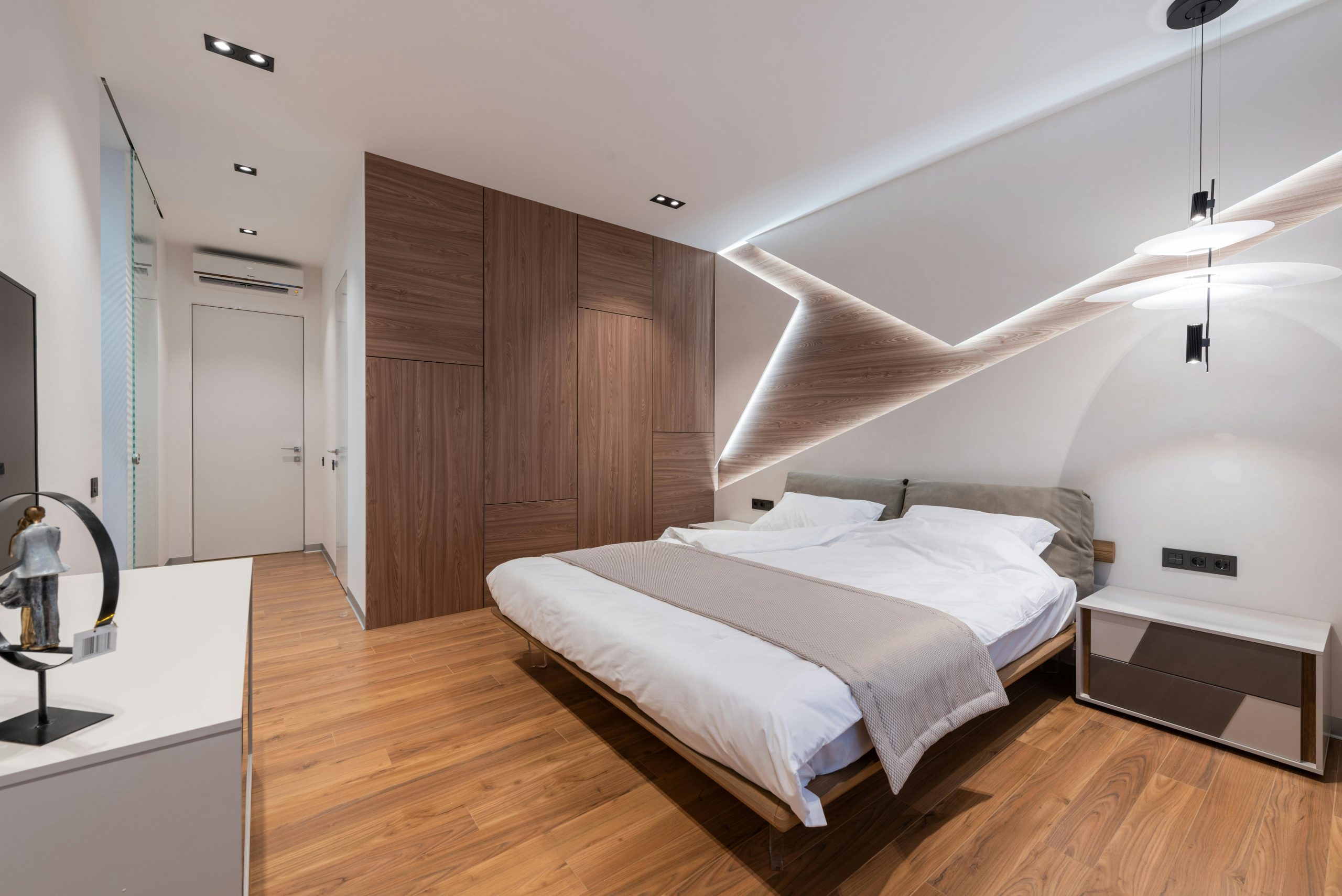 modern hotel room featuring white walls and a wooden accent wall